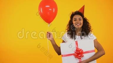 快乐的少年拿着气球和巨大的礼品盒，庆祝生日，问候